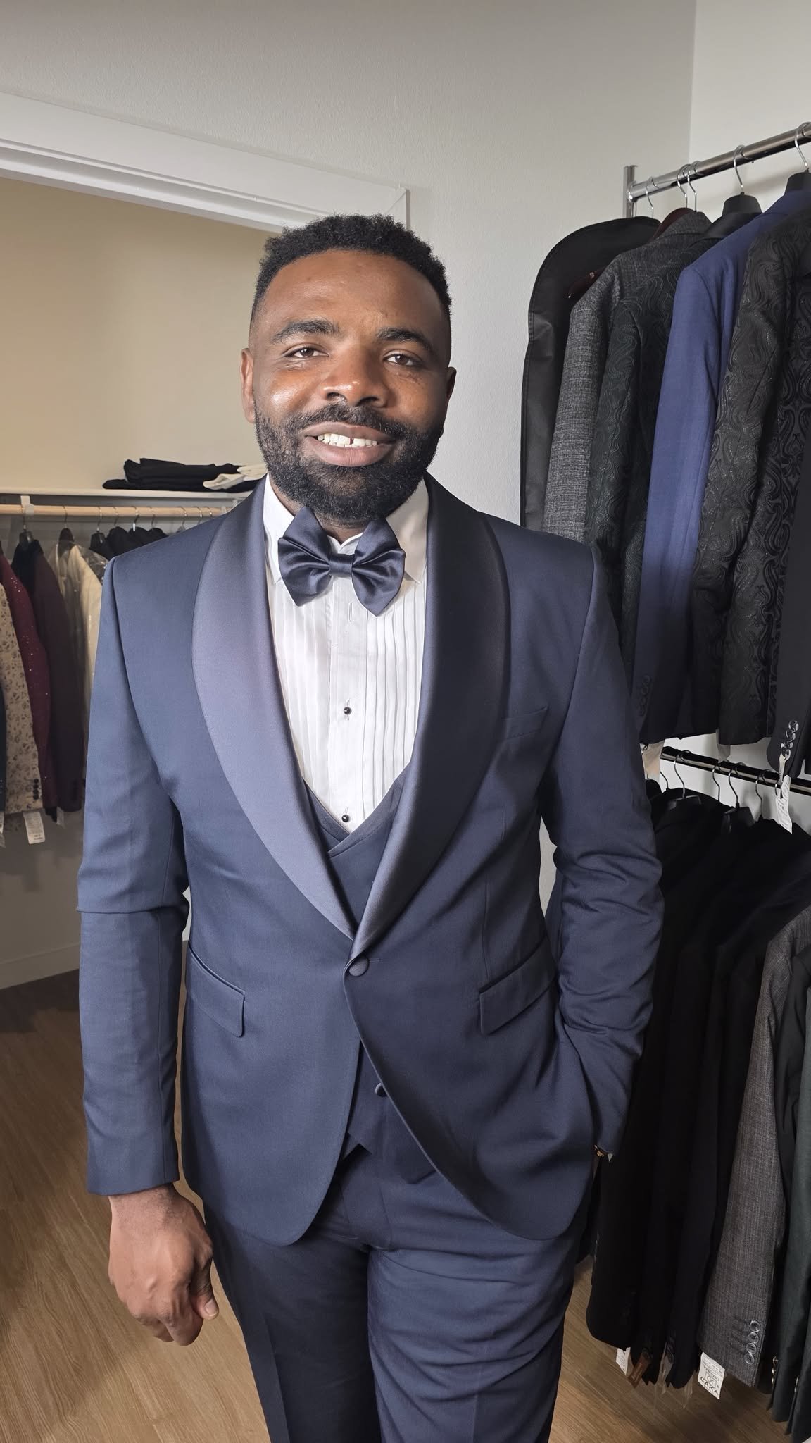Che Signature Suits founder Mr. Che M. wearing a navy formal suit and bow tie